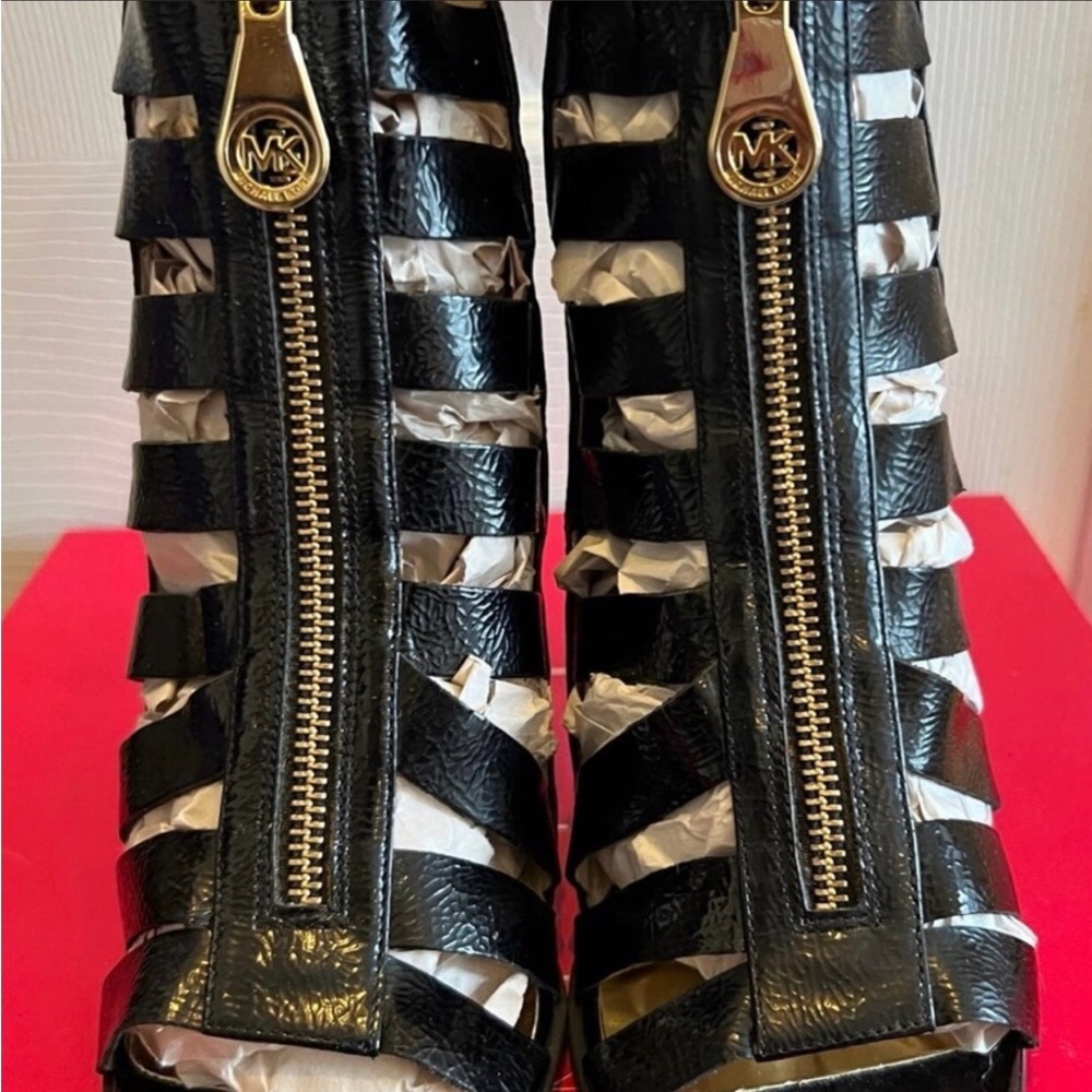 Michael Kors black Cage Booties in black soft patent leather with gold zippers.
